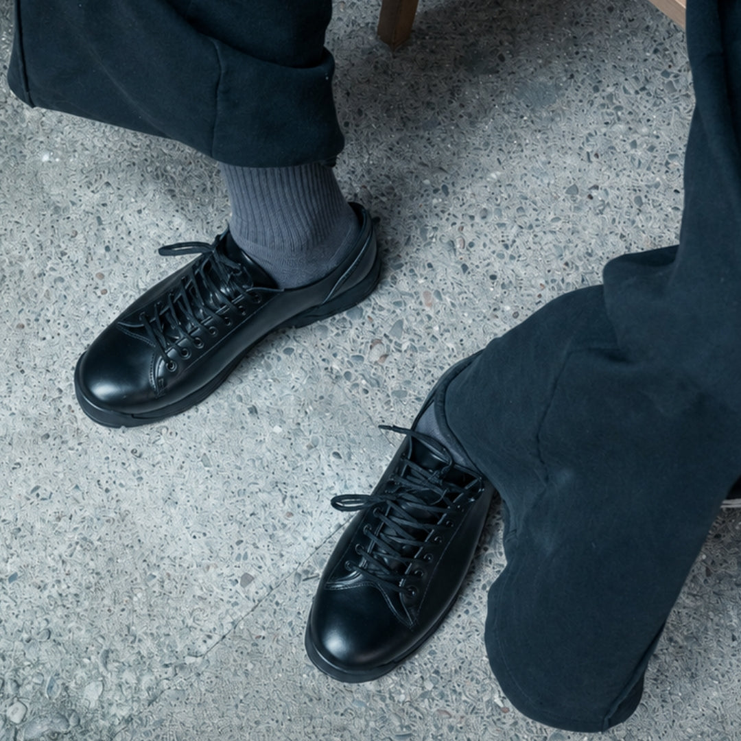 OSWEN City Explorer Low black leather lace-up shoes worn outdoors.